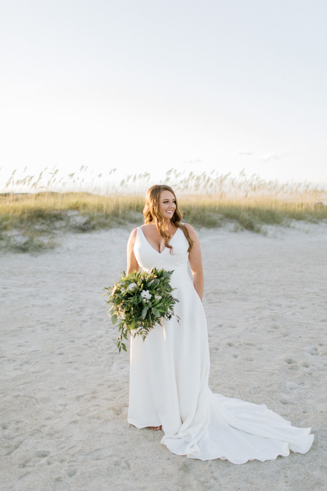 bride looking out to sea with bouquet