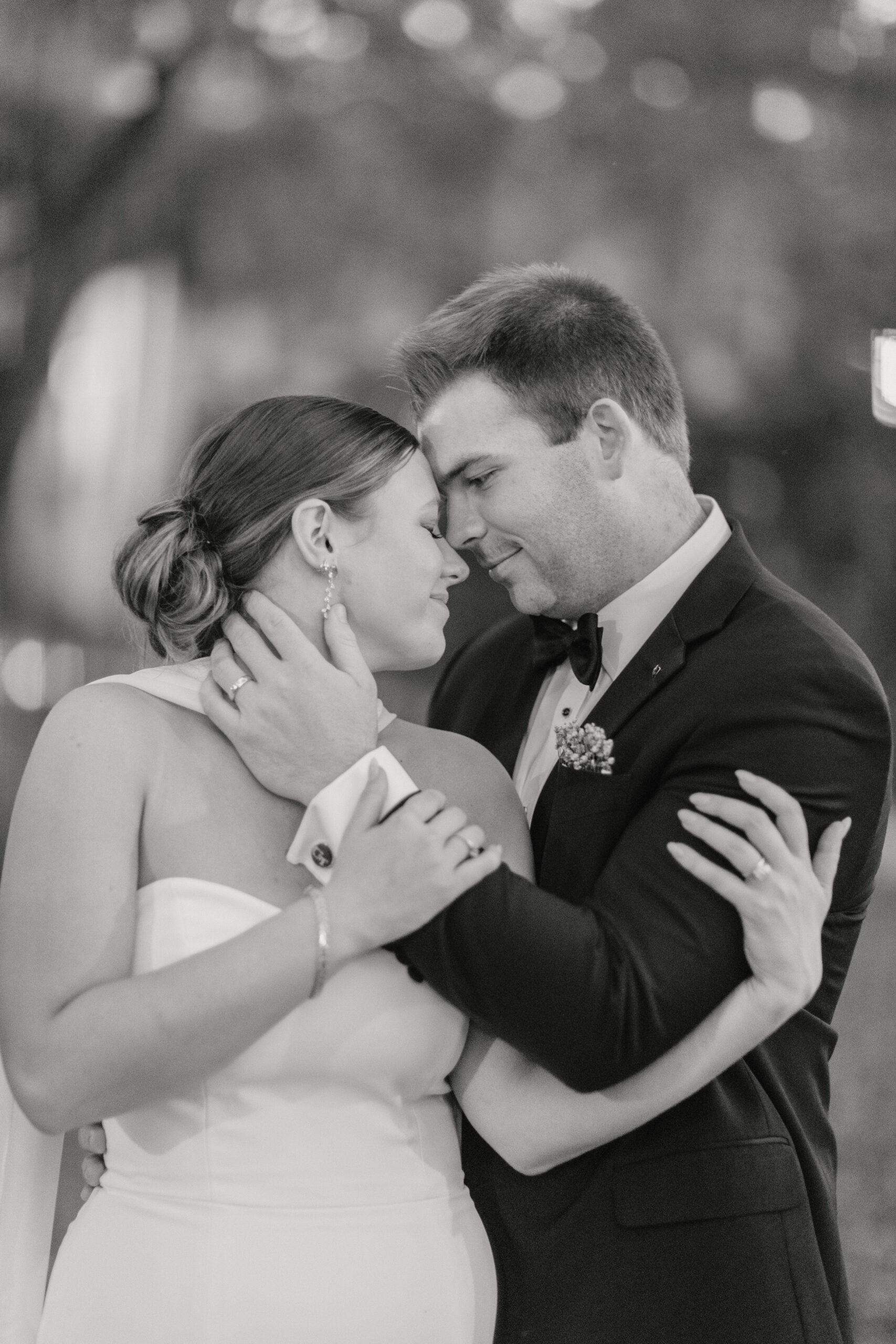 Bride and groom wrap arms around each other. Black and white image in downtown Savannah, GA
