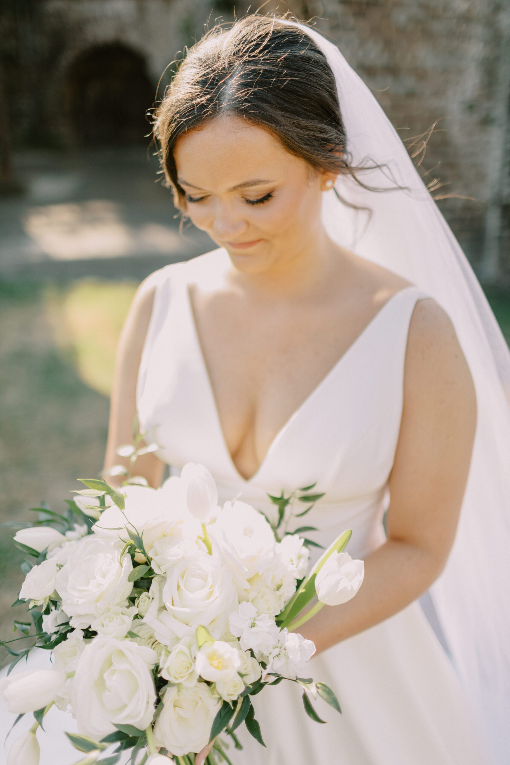 savannah wedding photography of gorgeous brunett bride holding bouquet of assorted white and green florals.