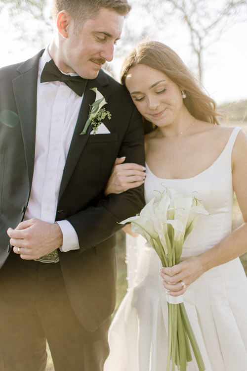 Elizabeth and Zachery wrapped in each other’s arms during their St. Simons Island wedding with the Georgia marsh stretching behind them
